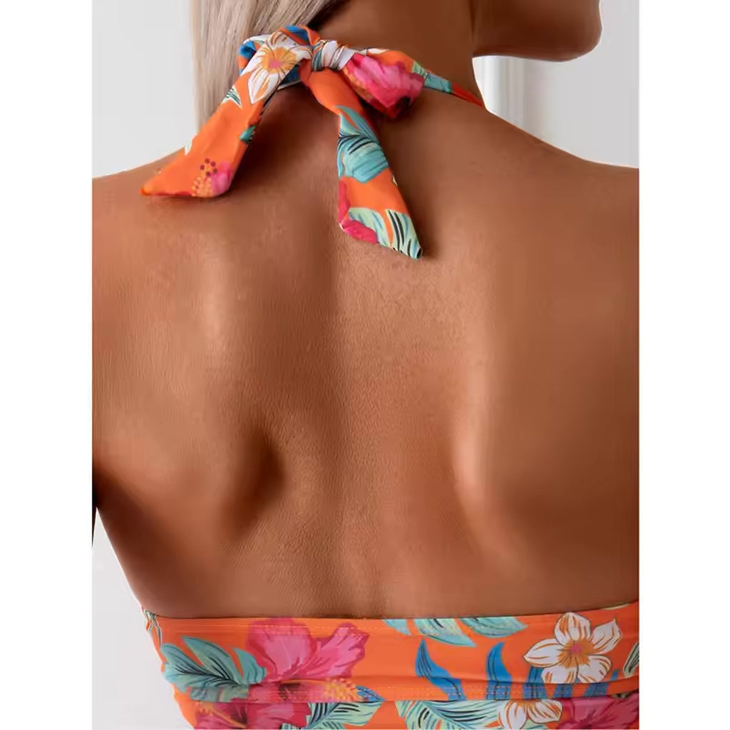 Flaunfit bikini with vibrant floral print on orange halter top, featuring pink and white flowers with teal accents.