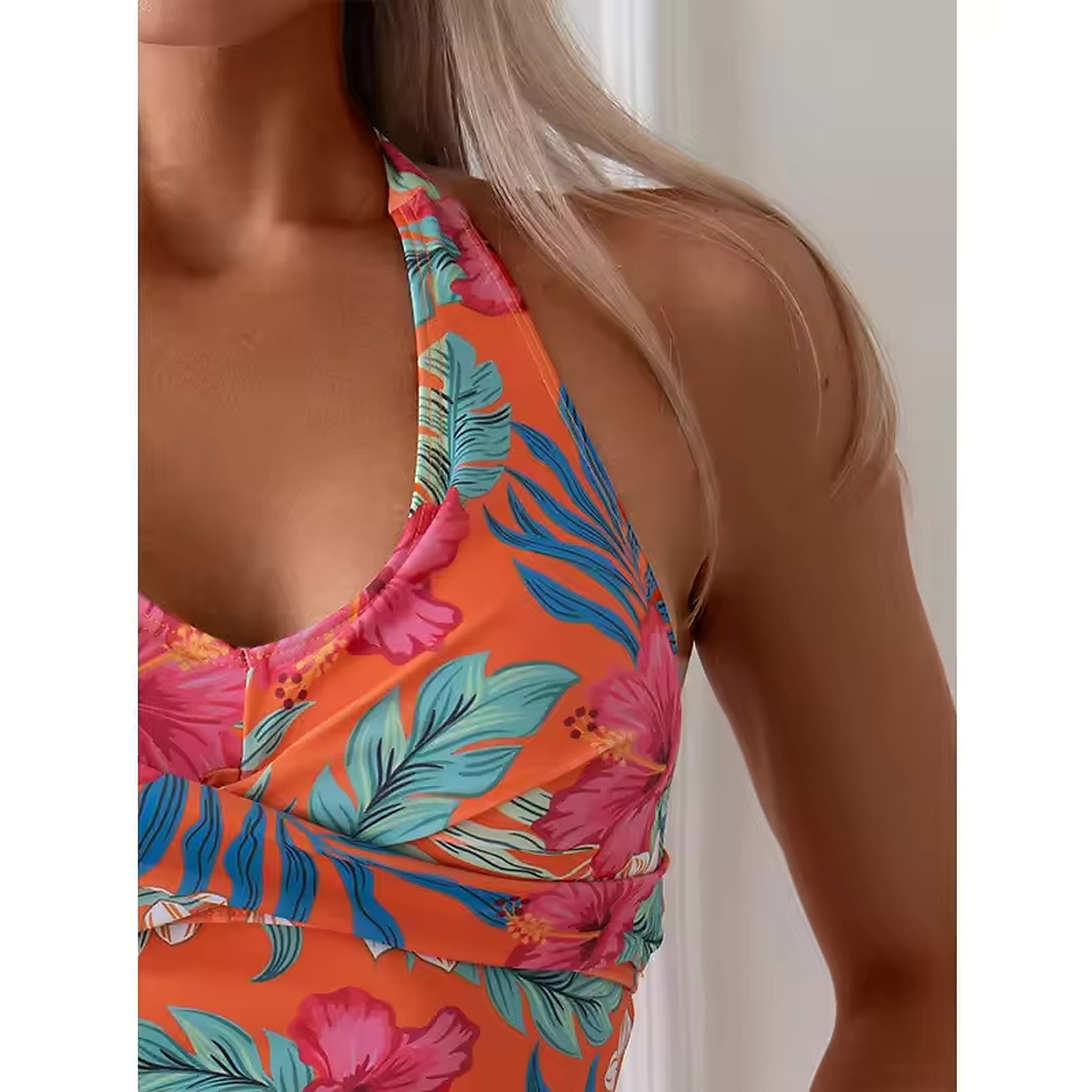 Colorful tropical floral bikini top in orange and pink with blue leaf details and ruched sides