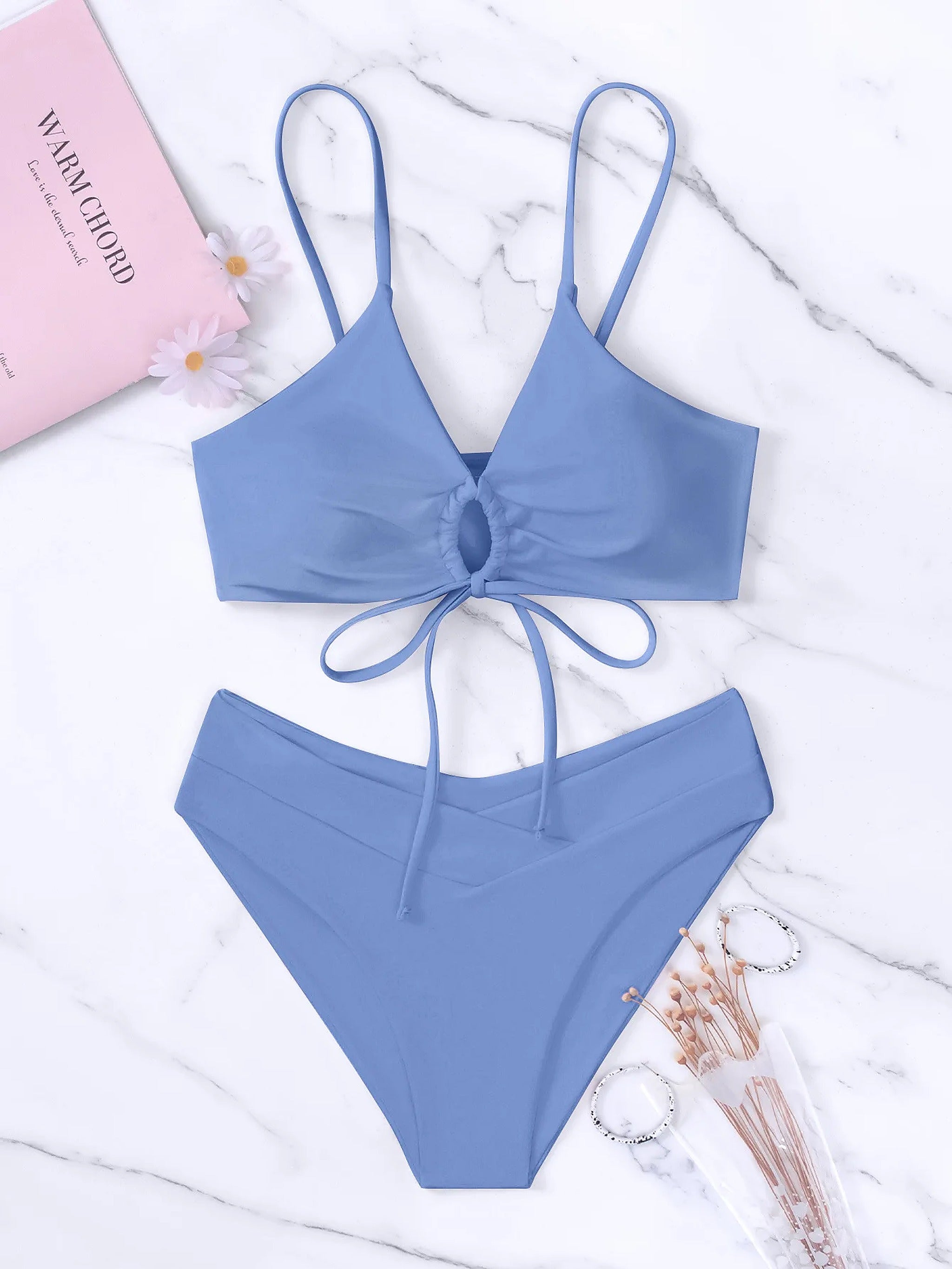 Periwinkle blue bikini with tie-front top and high-waisted bottom on marble background