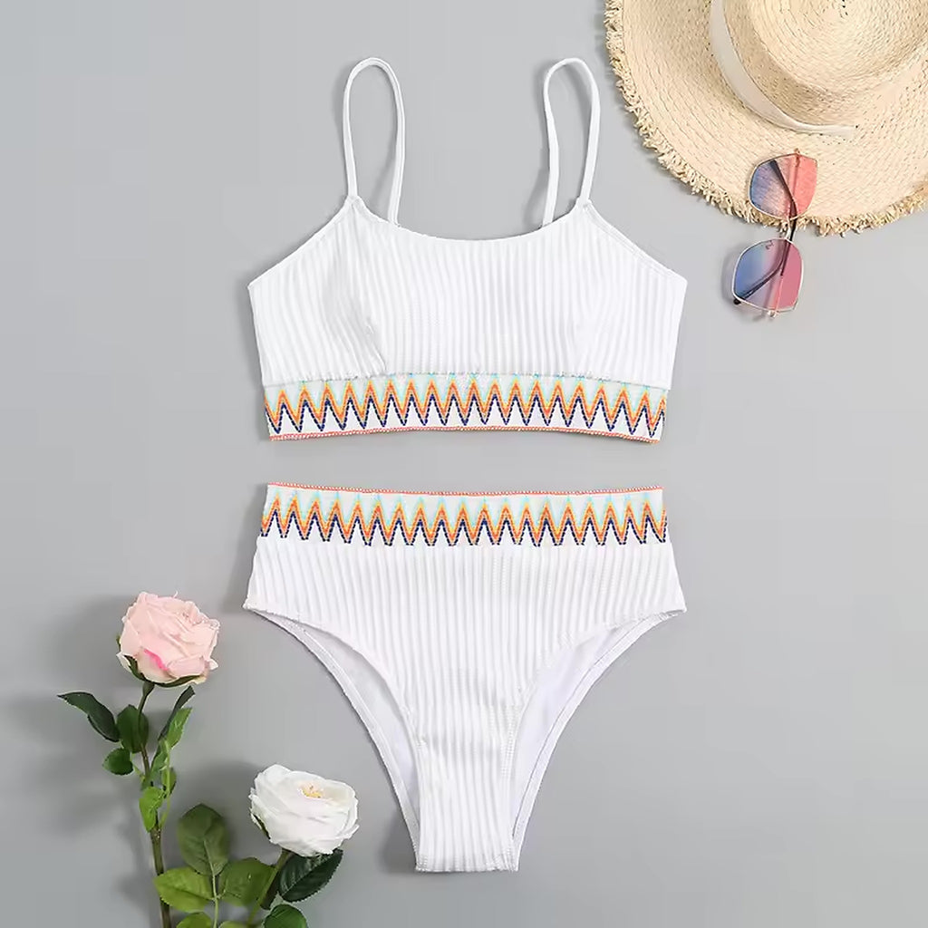 White ribbed bikini with colorful geometric trim, styled with straw hat and sunglasses