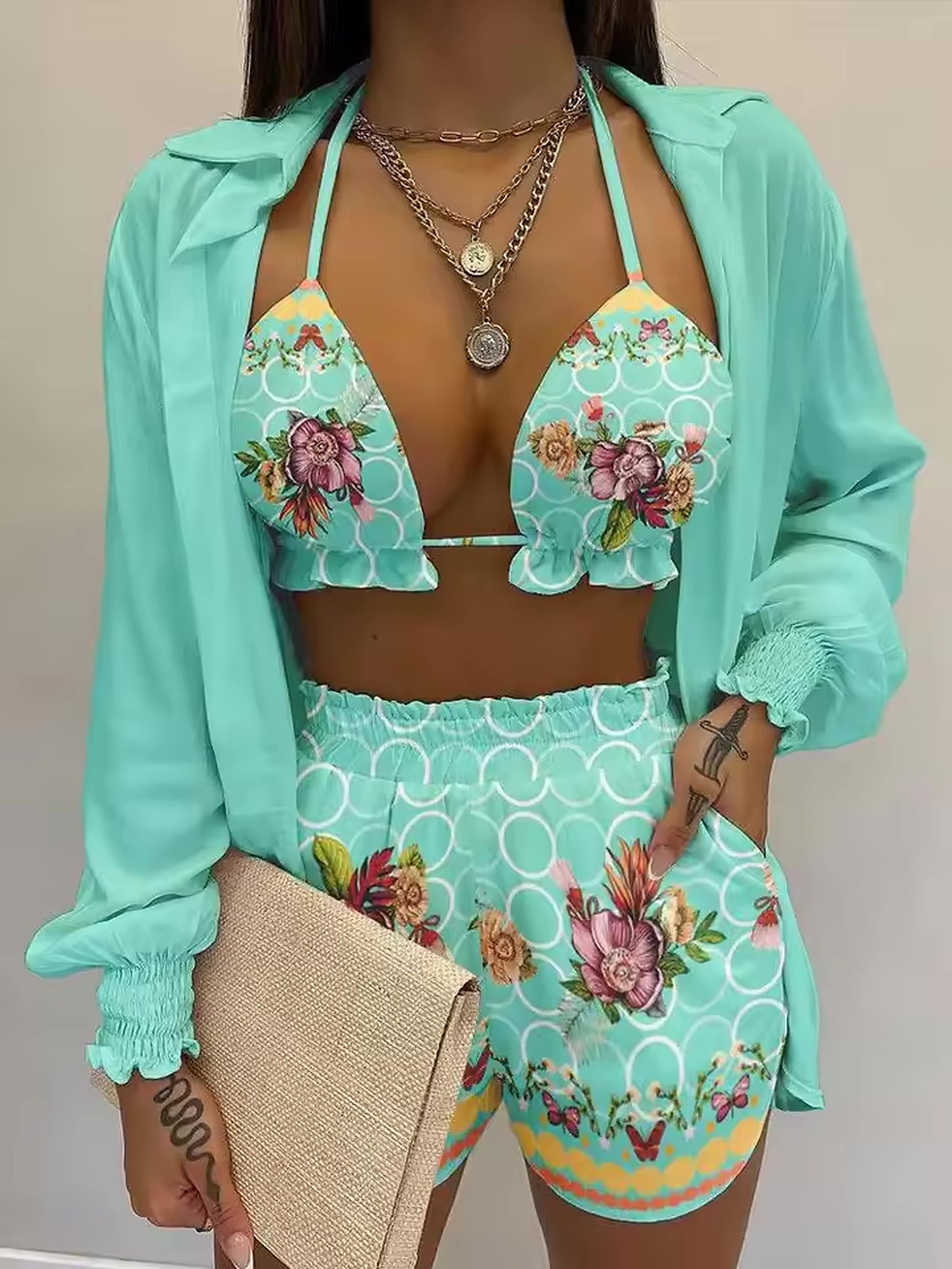 Mint green floral bikini with geometric pattern, matching cover-up shirt, and coordinating accessories
