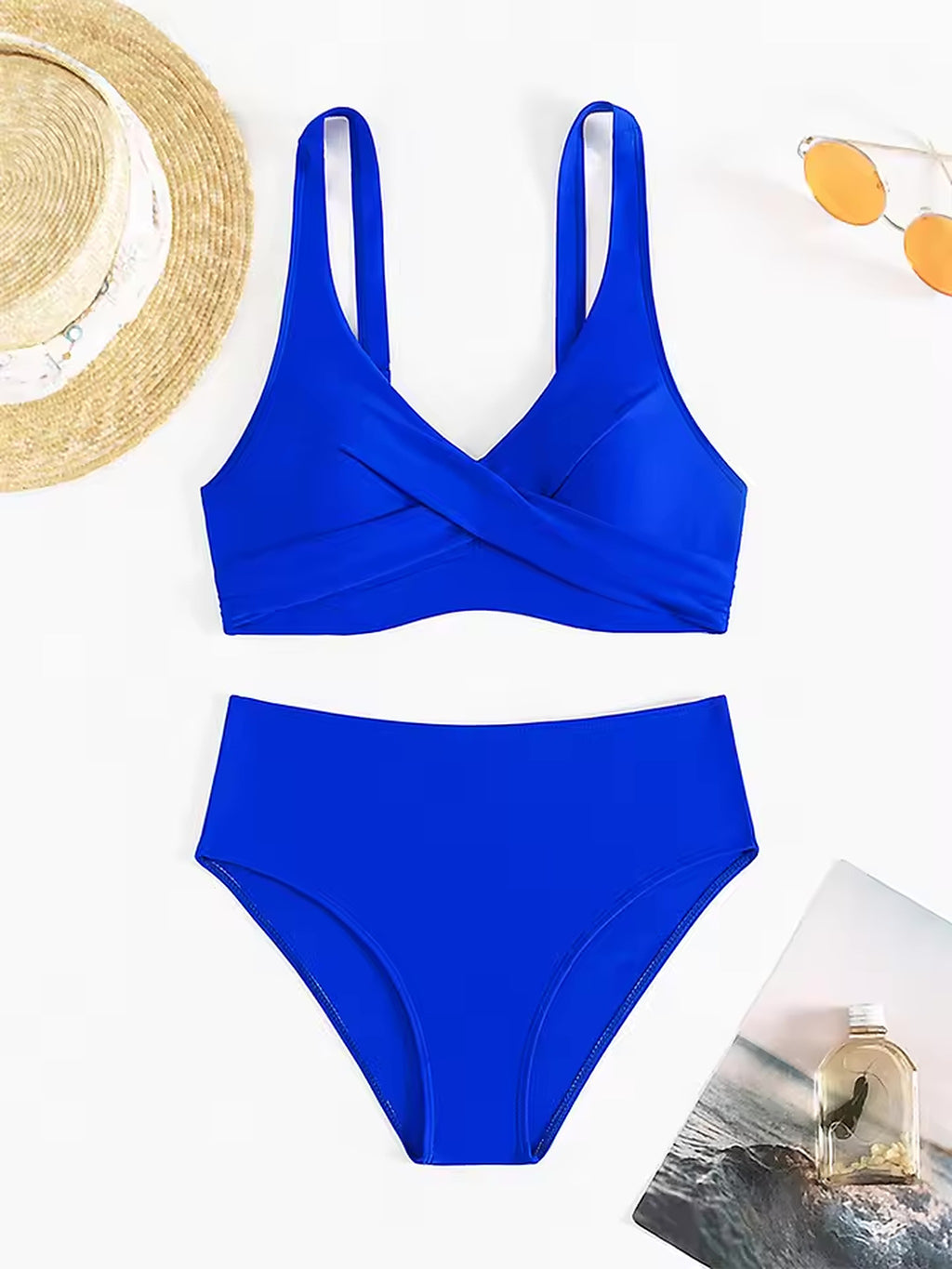 Bright blue wrap-front bikini top and high-waisted bottom displayed with straw hat and sunglasses