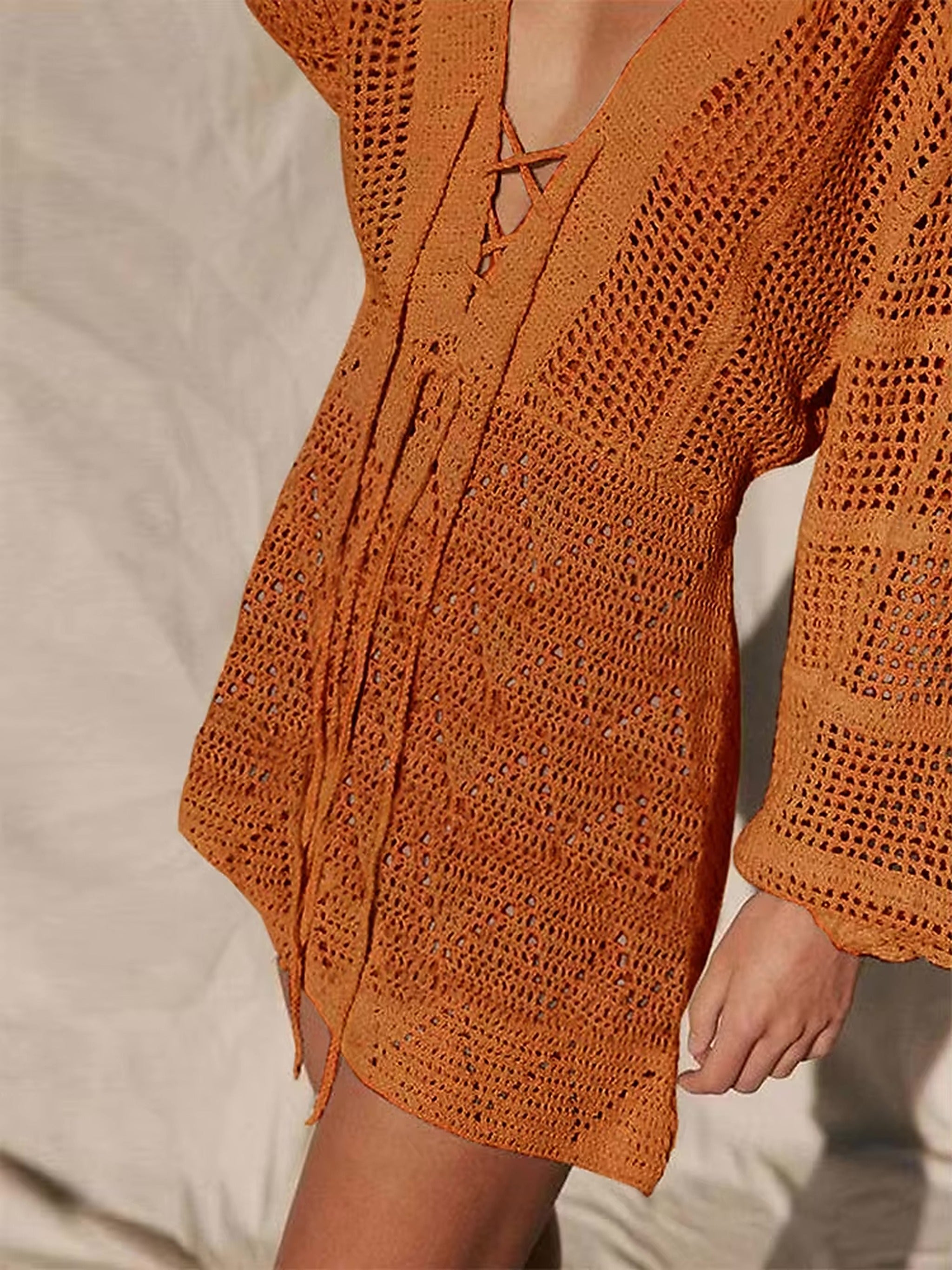 Burnt orange crochet bikini cover-up with openwork knit texture and tie-front closure detail.